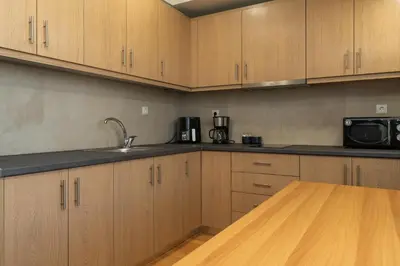 a kitchen with wooden cabinets and a sink and a microwave at Kifisias View Apartment 1 in Athens
