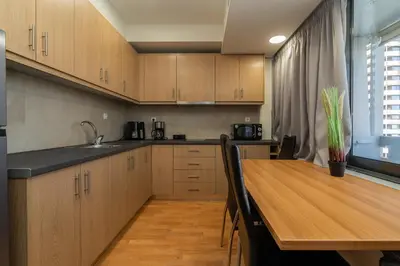 a kitchen with wooden cabinets and a wooden table at Kifisias View Apartment 1 in Athens