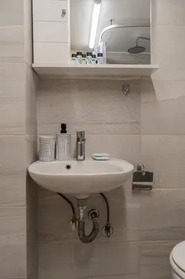 a bathroom with a white sink and a toilet at Kifisias View Apartment 1 in Athens
