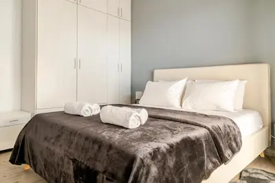 a bedroom with a bed with two towels on it at Eclipse Vouliagmeni Center in Athens