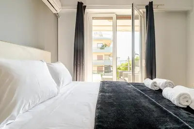 a bedroom with a white bed with towels on it at Eclipse Vouliagmeni Center in Athens