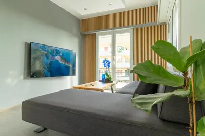 a living room with a couch and a plant at Eclipse Vouliagmeni Center in Athens