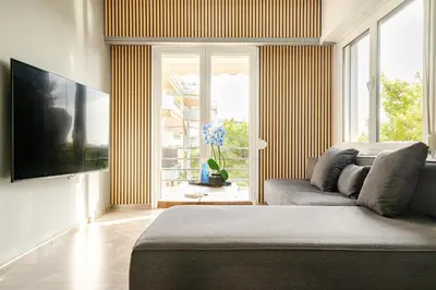 a living room with a couch and a large window at Eclipse Vouliagmeni Center in Athens