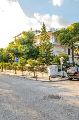 a street with a car parked in front of a building at Eclipse Vouliagmeni Center in Athens