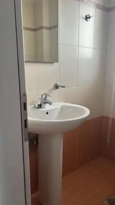 a bathroom with a white sink and a mirror at Spacious & Modern seaside house in Piraeus