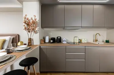 a kitchen with gray cabinets and a wooden counter top at The Athenian Aroma - Suite with Jacuzzi in Athens