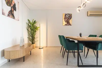 a dining room with a table and green chairs at Modern Seaside 2BR APT in Athens