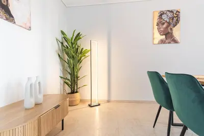 a living room with a table and two green chairs at Modern Seaside 2BR APT in Athens