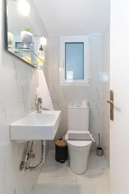 a white bathroom with a sink and a toilet at Modern Seaside 2BR APT in Athens