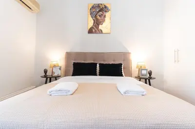 a bedroom with a large bed with two towels on it at Modern Seaside 2BR APT in Athens