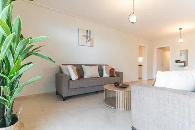 a living room with a couch and a table at Modern Seaside 2BR APT in Athens