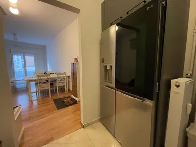 a kitchen with a refrigerator and a dining room with a table at Xenia's Elegant Acropolis Suite in Athens