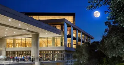 a large building with a full moon in the sky at Xenia's Elegant Acropolis Suite in Athens