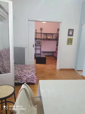 a living room with a bed and a table at LUCY maison in Athens