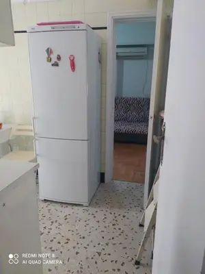 a white refrigerator in a kitchen with a bedroom at LUCY maison in Athens