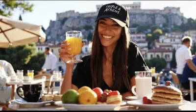 a woman sitting at a table with a glass of orange juice at Triple A - Psiri Urban Glow Studios at Theatrou Square II Free Parking! in Athens