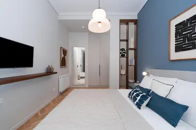 a living room with a bed and a flat screen tv at Spacious & Stylish Athens Apartment - Walk to Metro in Athens