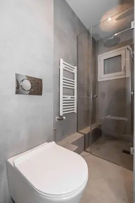 a bathroom with a toilet and a shower at Spacious & Stylish Athens Apartment - Walk to Metro in Athens