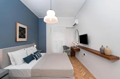 a bedroom with a large bed with blue walls at Spacious & Stylish Athens Apartment - Walk to Metro in Athens