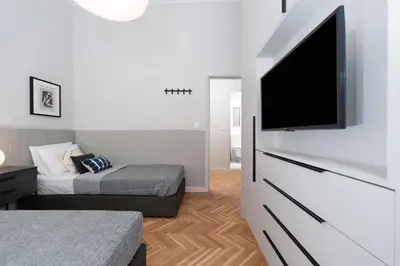 a bedroom with a flat screen tv and a bed at Spacious & Stylish Athens Apartment - Walk to Metro in Athens