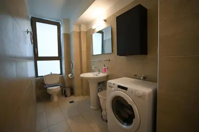 a bathroom with a washing machine and a sink at Tsakalof Penthouse by Zeus Suites in Athens