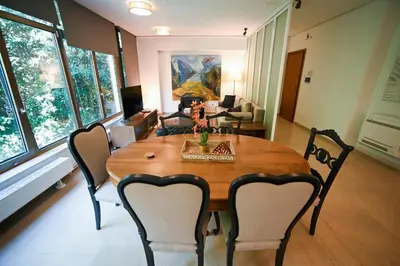 a living room with a wooden table and chairs at Tsakalof Penthouse by Zeus Suites in Athens
