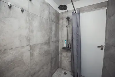 a shower with a glass door in a bathroom at Tsakalof 10A in Athens