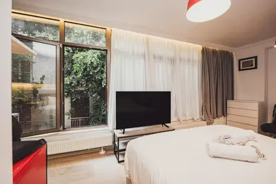 a bedroom with a bed and a large window at Tsakalof 10A in Athens
