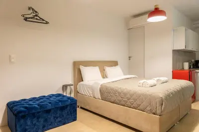a bedroom with a bed and a blue ottoman at Tsakalof 10A in Athens