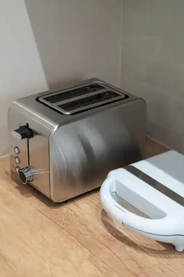a toaster sitting on top of a wooden floor at Charming minimal apt in the center of Glyfada in Athens