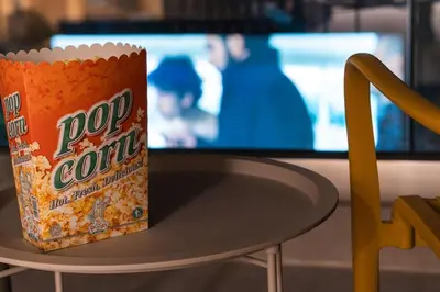 a box of popcorn sitting on a table in front of a tv at Charming minimal apt in the center of Glyfada in Athens