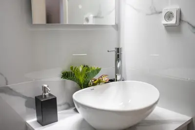 a bathroom with a white sink and a mirror at Stylish Koukaki Retreat by the Acropolis in Athens