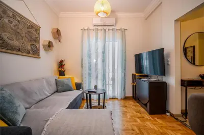 a living room with a couch and a tv at Stylish Koukaki Retreat by the Acropolis in Athens