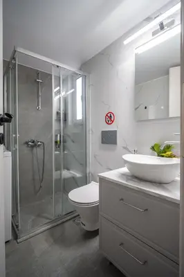 a bathroom with a shower and a toilet and a sink at Stylish Koukaki Retreat by the Acropolis in Athens