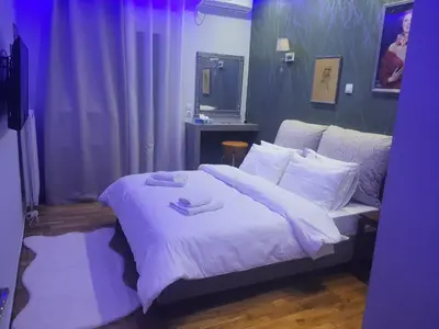 a bedroom with a bed with white sheets and pillows at Apartament Fbi in Athens