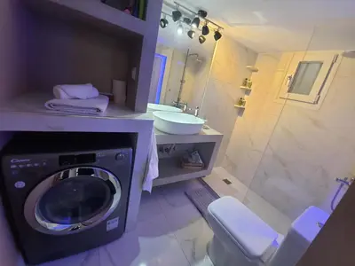 a bathroom with a washing machine and a sink at Apartament Fbi in Athens