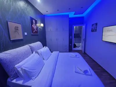 a bedroom with a large bed with blue lighting at Apartament Fbi in Athens