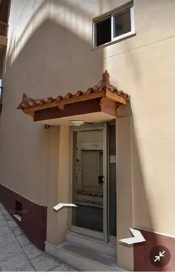 a entrance to a building with a window and a roof at Thiseio Home in Athens