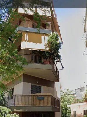 a building with a balcony with potted plants on it at Thiseio Home in Athens