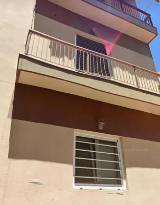 a tall building with a balcony and a window at Thiseio Home in Athens