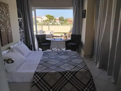 a hotel room with a bed and a table with chairs at Penthouse Peaceful Oasis in Lagonissi