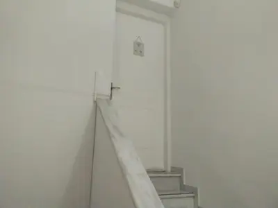 a stairway in a white room with a cross on the wall at Penthouse Peaceful Oasis in Lagonissi
