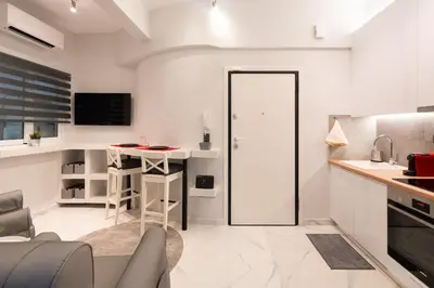 a living room with a kitchen with a table at Unique Urban Gem in Neapoli Exarcheia in Athens
