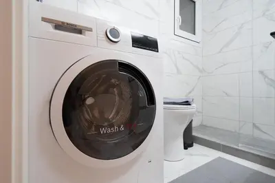a washing machine in a bathroom with a toilet at Unique Urban Gem in Neapoli Exarcheia in Athens