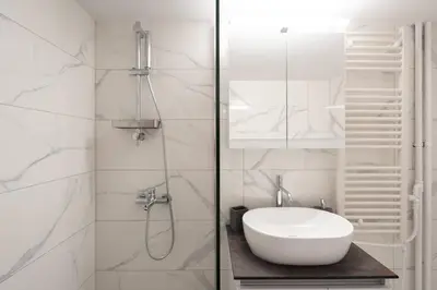 a white bathroom with a sink and a shower at Unique Urban Gem in Neapoli Exarcheia in Athens