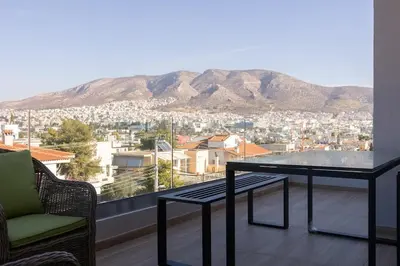 a balcony with a table and a view of a city at The Mint House - Alimos in Athens