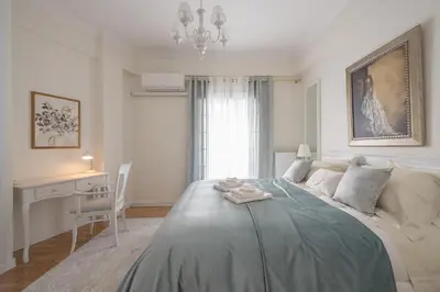 a bedroom with a bed with a table and a desk at Brand New Luxury Apt Below Acropolis in Athens
