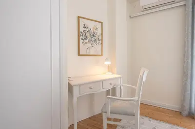 a white desk with a lamp and a chair in a room at Brand New Luxury Apt Below Acropolis in Athens