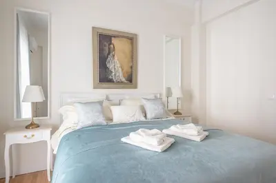 a bedroom with a blue bed with towels on it at Brand New Luxury Apt Below Acropolis in Athens