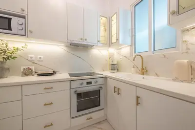 a white kitchen with white cabinets and a sink at Brand New Luxury Apt Below Acropolis in Athens